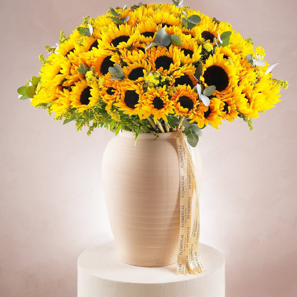 Luxury oversized sunflower vase arrangement with eucalyptus and solidago by Flowers.ae Dubai